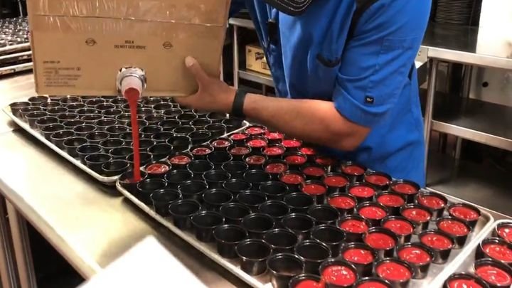 Сотрудник ресторана за считанные секунды заполняет кетчупом 70 порционных формочек