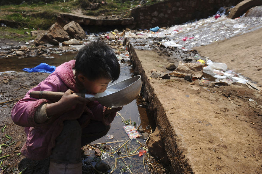 11. Ребёнок пьёт воду из грязного ручья в Фуюань, провинция Юньнань загрязнение, мир, фото
