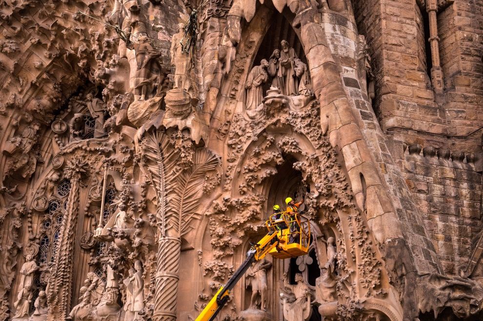 Рабочие трудятся у фасада Храма Святого Семейства в Барселоне. барселона, строительство, храм