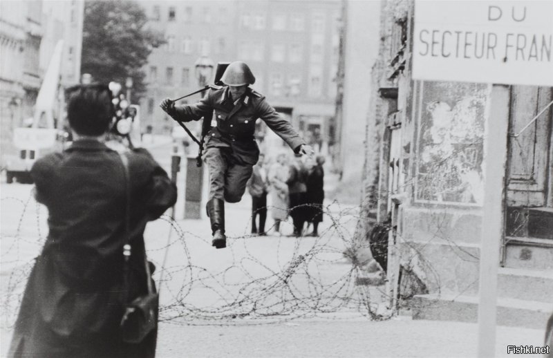 В реале подобных случаев была тьма. Причём бежали почему-то исключительно от счастливого коммунистического строя в загнивающую западную Германию. Так что нечего цепляться к одному фейку, теряющемуся на фоне сотен реальных случаев. 

Солдат бежит от коммунистического "счастья" из Восточной в Западную Германию во время строительства Берлинской стены в 1961.